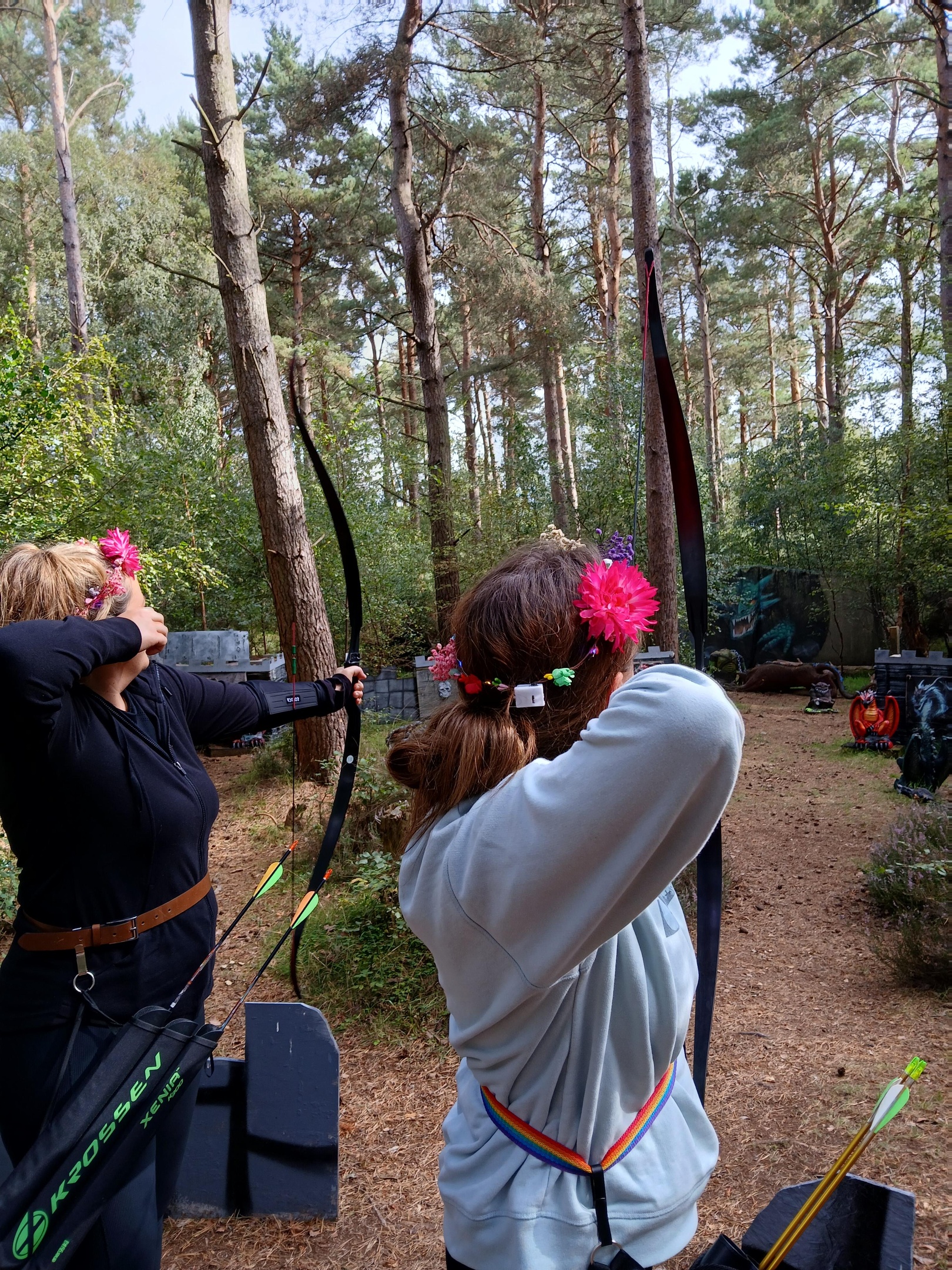 Two ladies shooting at dragon targets in an archery centre