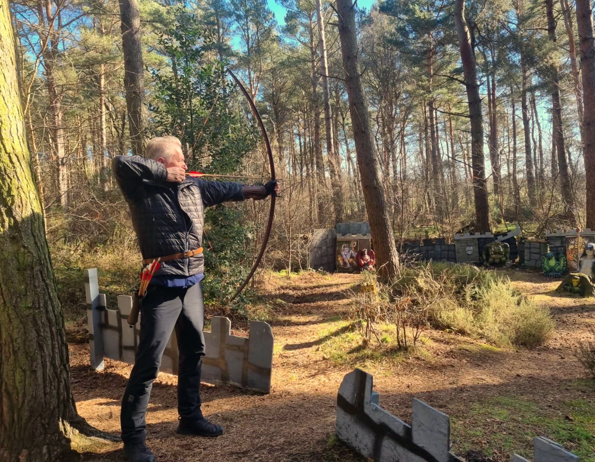 small family group enjoying longbow archery in the woods