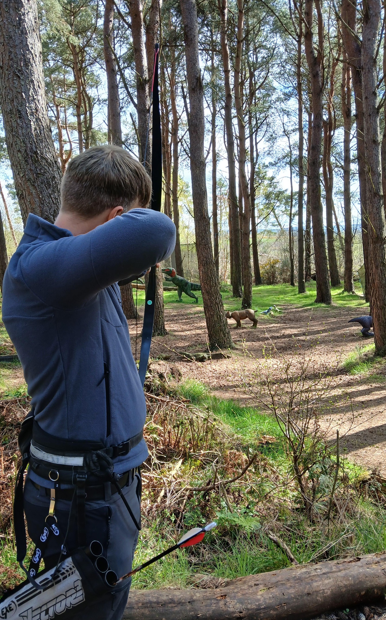 man shooting at dinosaur targets in an archery centre