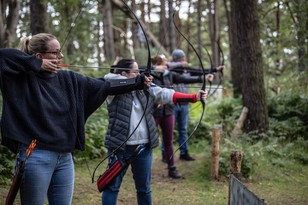 Group of friends enjoying field archery in the woods