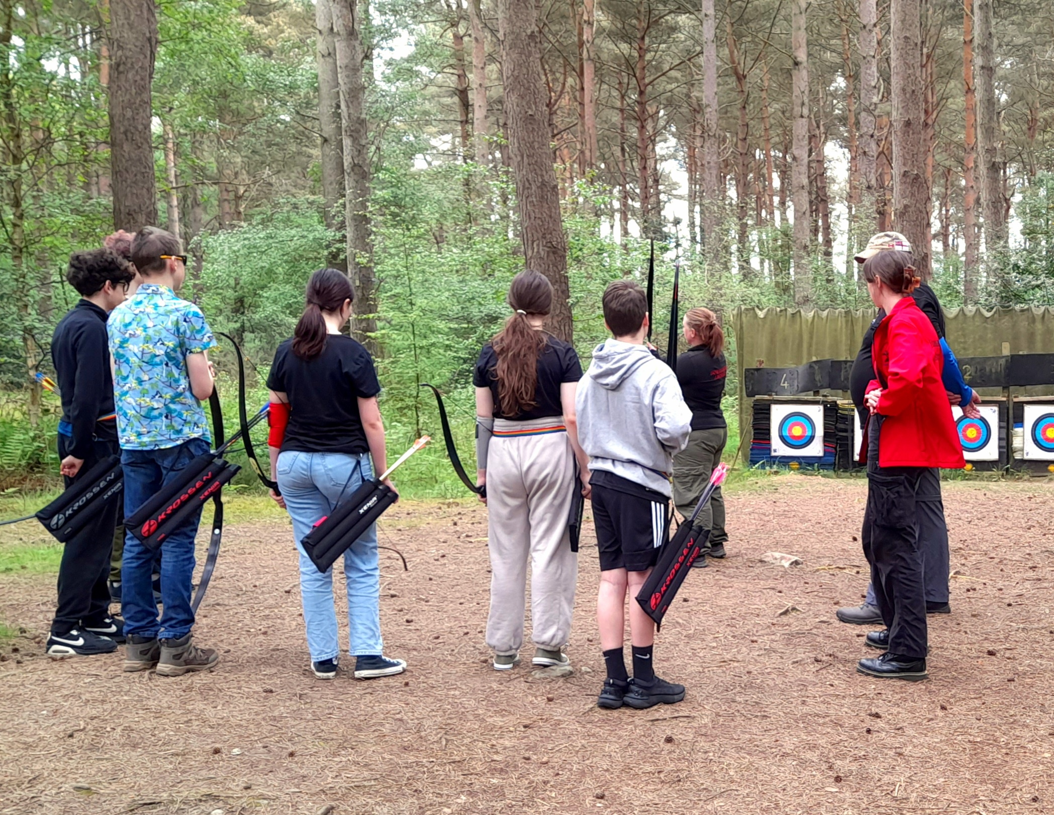 Group of young people learning archery